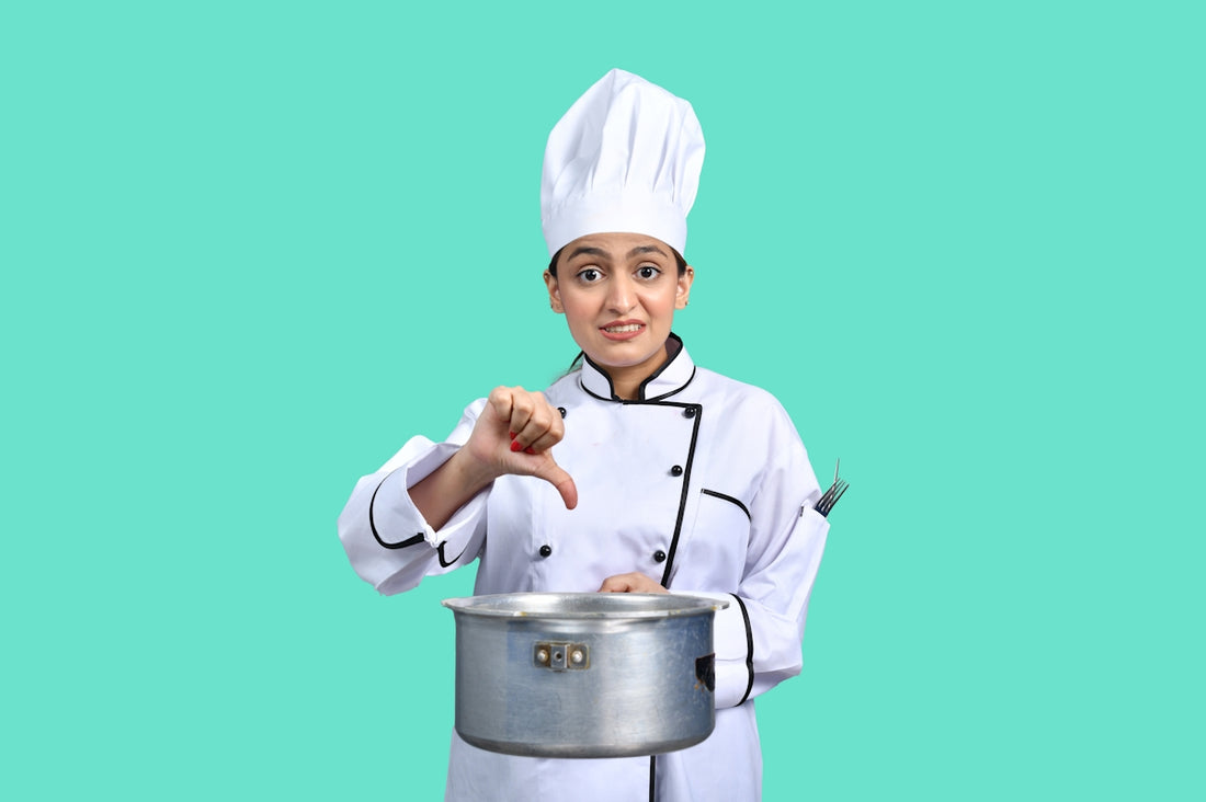 a young boy wearing a chef's hat and holding a silver pot